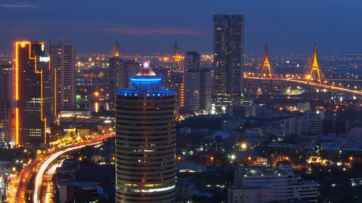 Skyline de Bangkok à l’heure bleue, gratte-ciel et ponts illuminés dans une profonde perspective urbaine